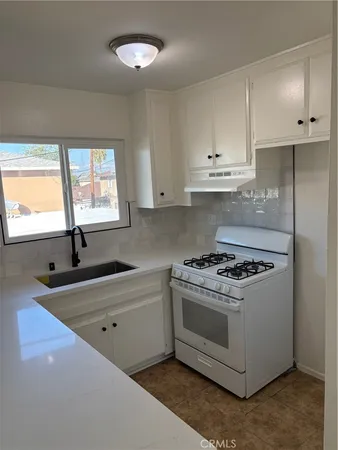 a kitchen with a stove a sink and a microwave