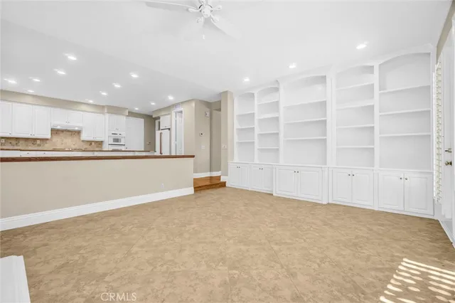 a view of an empty room with window and hardwood floor