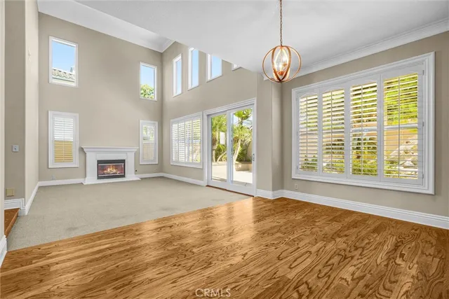 a view of an empty room with a window and a kitchen