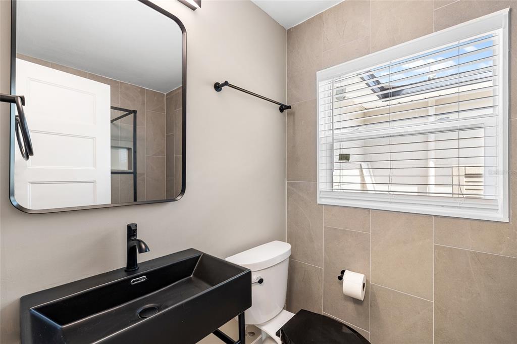 231 East Madeira Avenue Madeira Beach, FL 33708 - Photo 19 of 60 a bathroom with a sink a mirror and a toilet