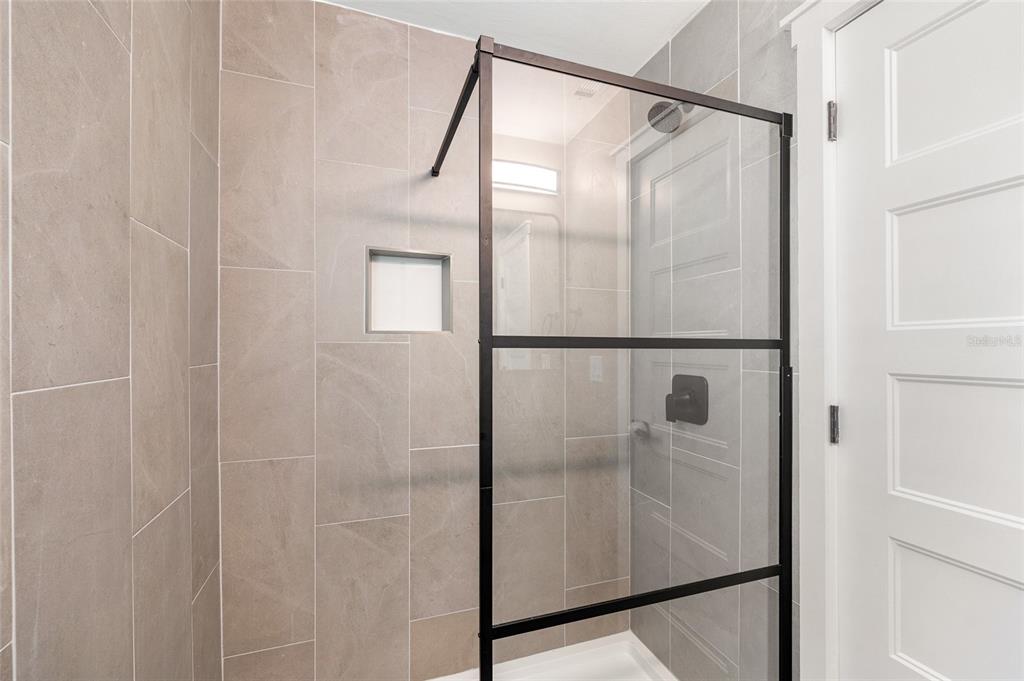231 East Madeira Avenue Madeira Beach, FL 33708 - Photo 20 of 60 a bathroom with a glass shower door