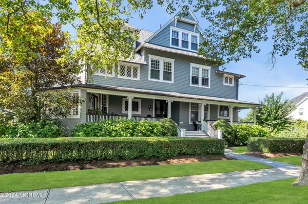 a front view of a house with a yard and potted plants