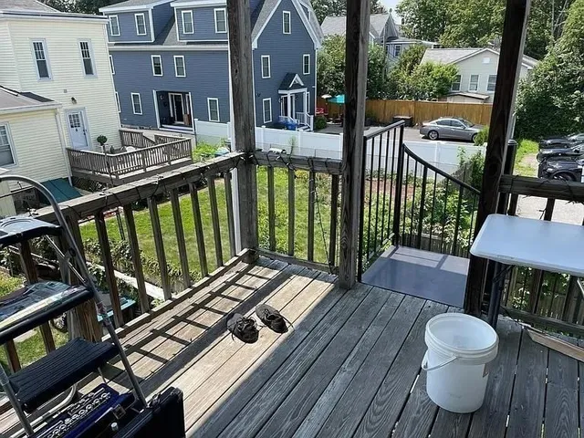 a view of a balcony with chairs and wooden floor