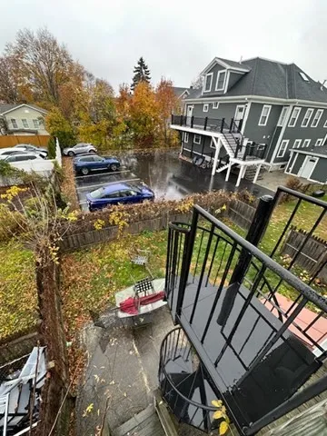 a view of a balcony with two chairs and a grill