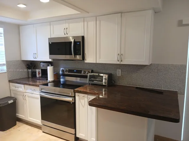 a kitchen with stainless steel appliances granite countertop a stove a microwave and oven