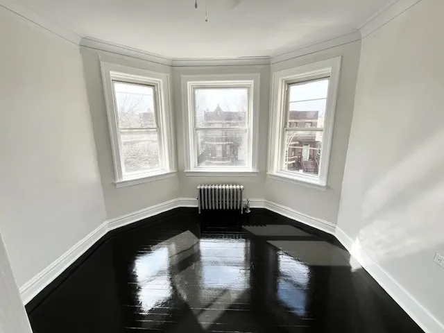 a living room with hardwood floor and a window