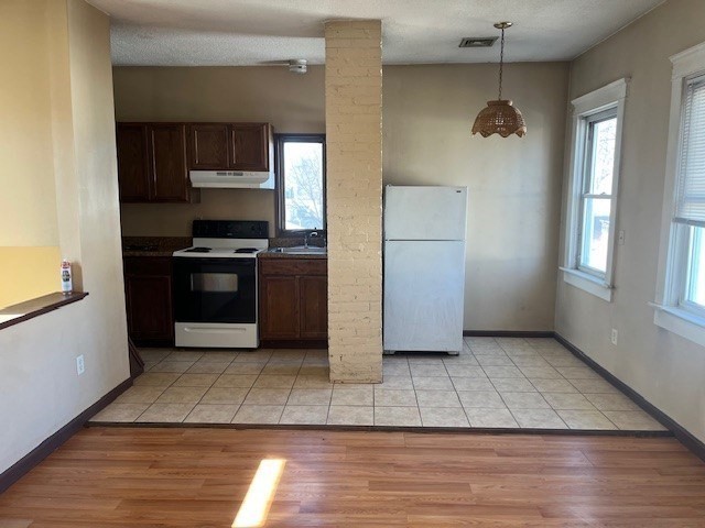 256 Broadway Taunton, MA 02780 - Photo 10 of 20 a view of a kitchen with a refrigerator a stove top oven and cabinets