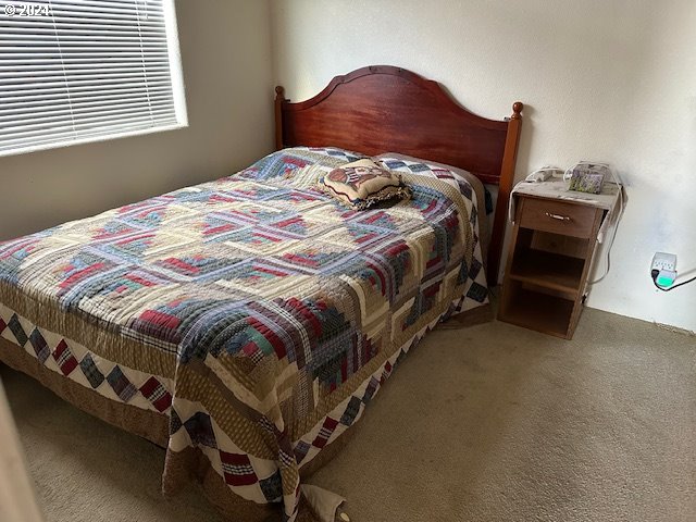 15061 Highway 101, Unit 4 Brookings, OR 97415 - Photo 10 of 12 a large bed sitting in a bedroom next to a window