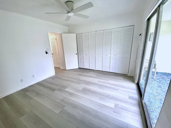 a view of a patio with table and chairs potted plants and floor to ceiling window