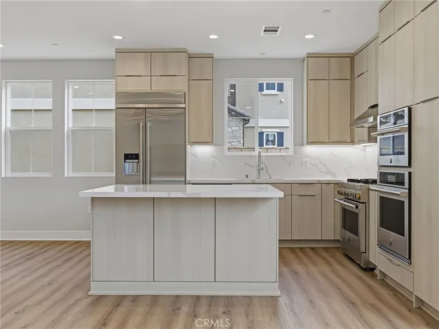 a kitchen with kitchen island white cabinets and stainless steel appliances
