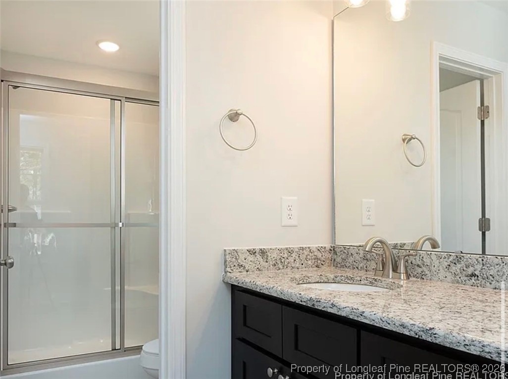 507 North Jackson Street Raeford, NC 28376 - Photo 11 of 17 a bathroom with a granite countertop sink and a mirror