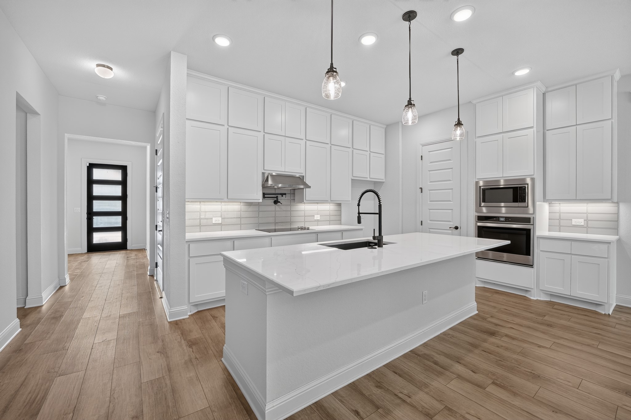 508 Pinnacle View Drive Georgetown, TX 78628 - Photo 5 of 27 Bright white kitchen featuring a generous island and modern pendant lights.