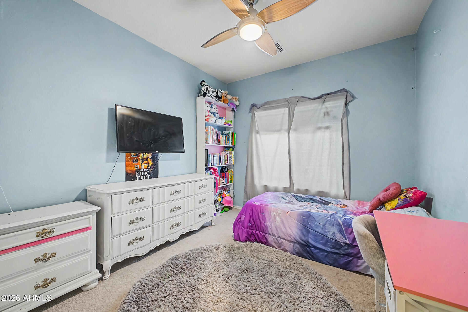 16719 West Rowel Road Surprise, AZ 85387 - Photo 16 of 28 a bedroom with a bed and flat tv screen on dresser