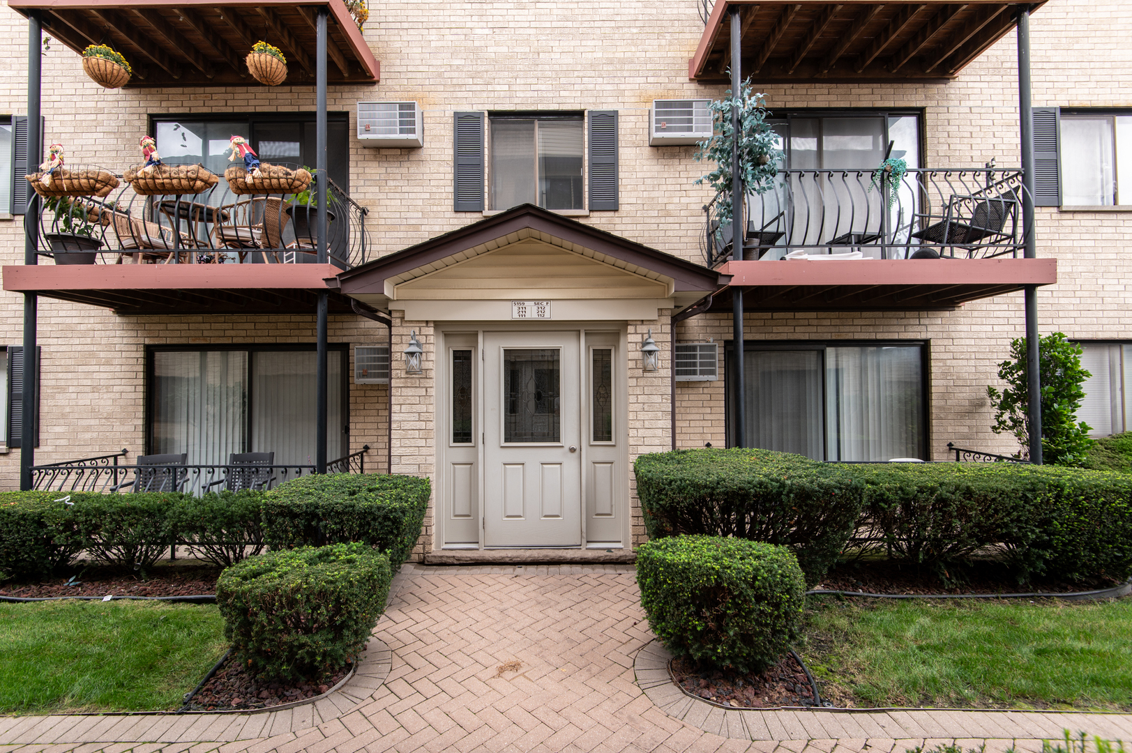 5159 North East River Road, Unit 312 Chicago, IL 60656 - Photo 39 of 42 a front view of a house with a yard and potted plants