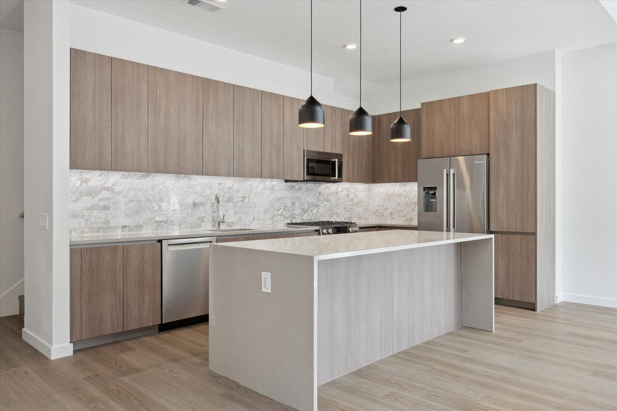 1 Riva Row, Unit 165 The Woodlands, TX 77380 - Photo 2 of 45 a kitchen with stainless steel appliances granite countertop a refrigerator a sink a stove and a wooden floors