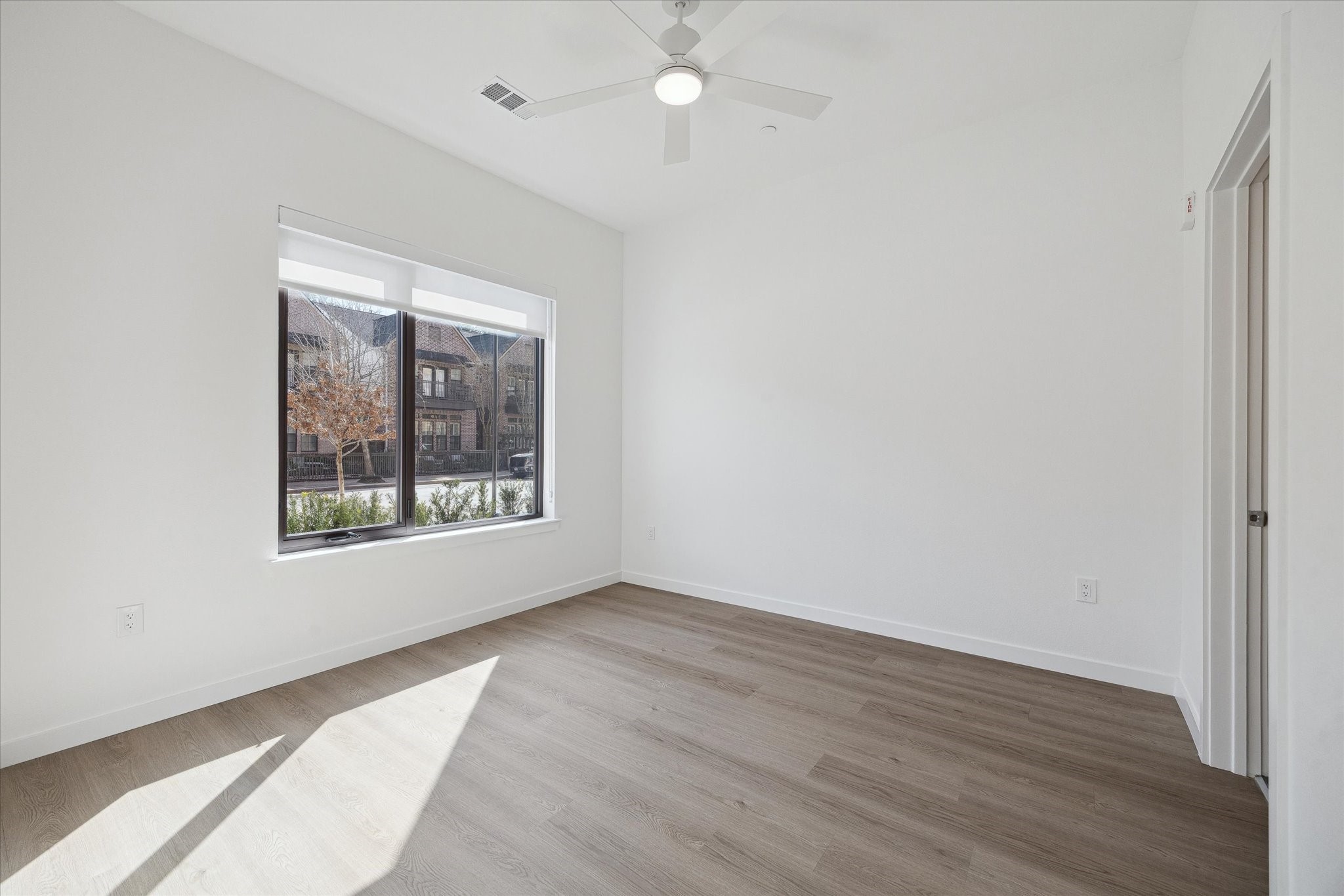 1 Riva Row, Unit 165 The Woodlands, TX 77380 - Photo 8 of 45 an empty room with wooden floor and windows