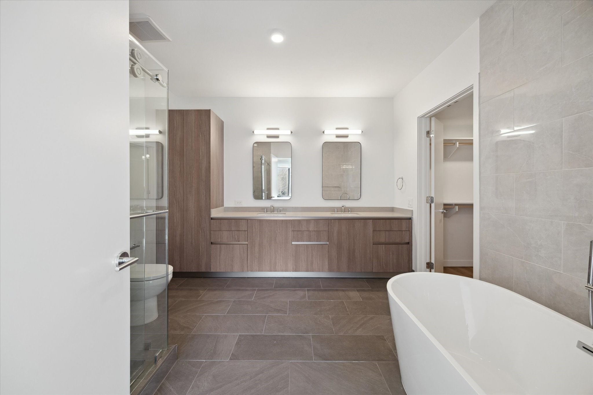 1 Riva Row, Unit 165 The Woodlands, TX 77380 - Photo 9 of 45 a bathroom with a tub a sink and a large mirror