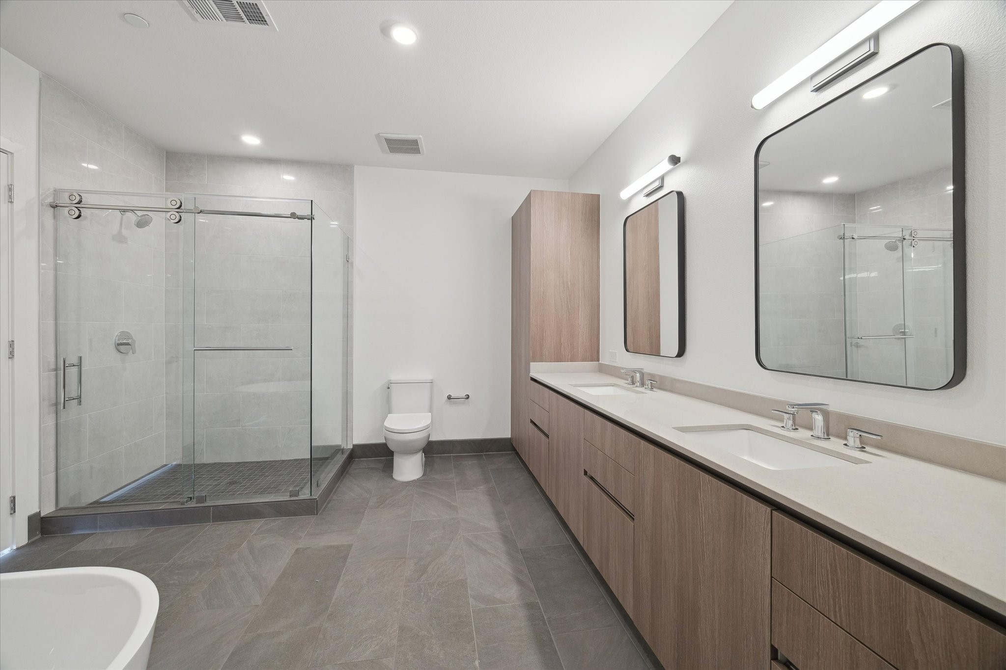 1 Riva Row, Unit 165 The Woodlands, TX 77380 - Photo 10 of 45 a bathroom with a double vanity sink mirror and toilet