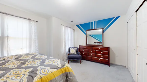a bedroom with a dresser and a window