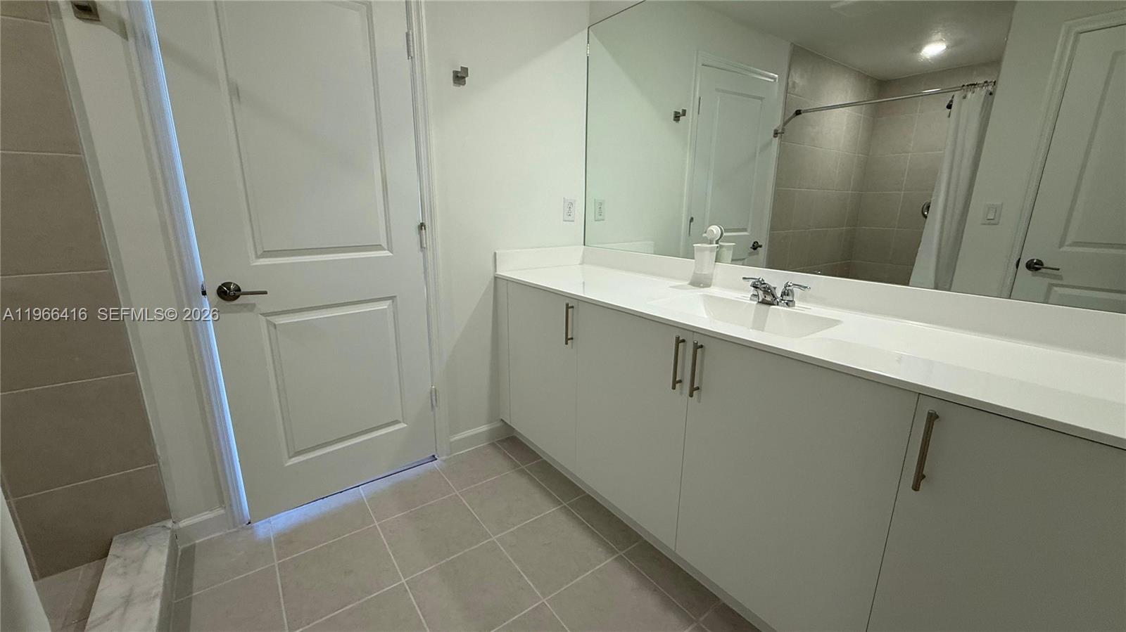 12420 Southwest 248th Street, Unit 10 Homestead, FL 33032 - Photo 12 of 16 a bathroom with a sink a mirror and a shower