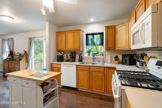 a kitchen with a stove a sink a window and cabinets