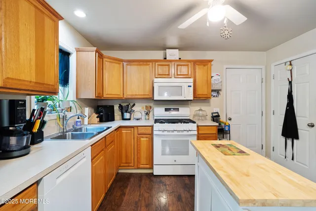 a kitchen with stainless steel appliances granite countertop a sink a stove and a wooden floors