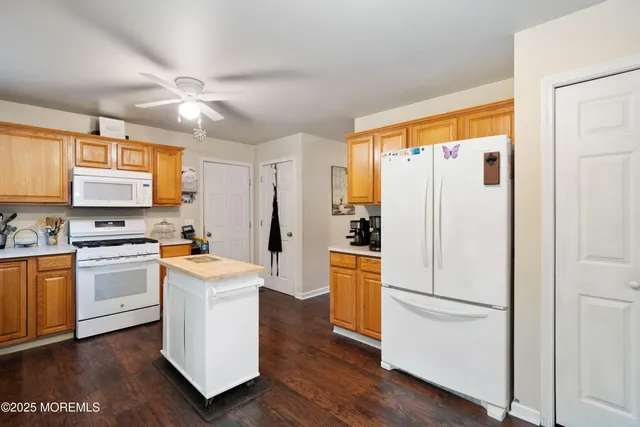 a kitchen with stainless steel appliances a refrigerator a stove a sink and white cabinets with wooden floor