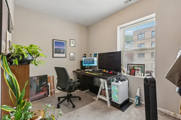 a view of a workspace with furniture and a window
