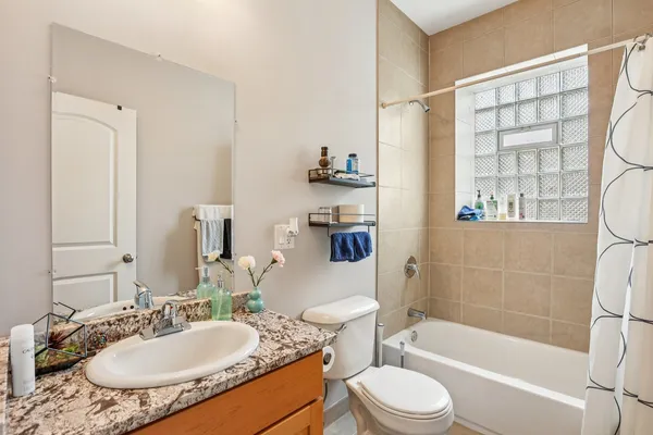 a bathroom with a granite countertop sink toilet a mirror and shower