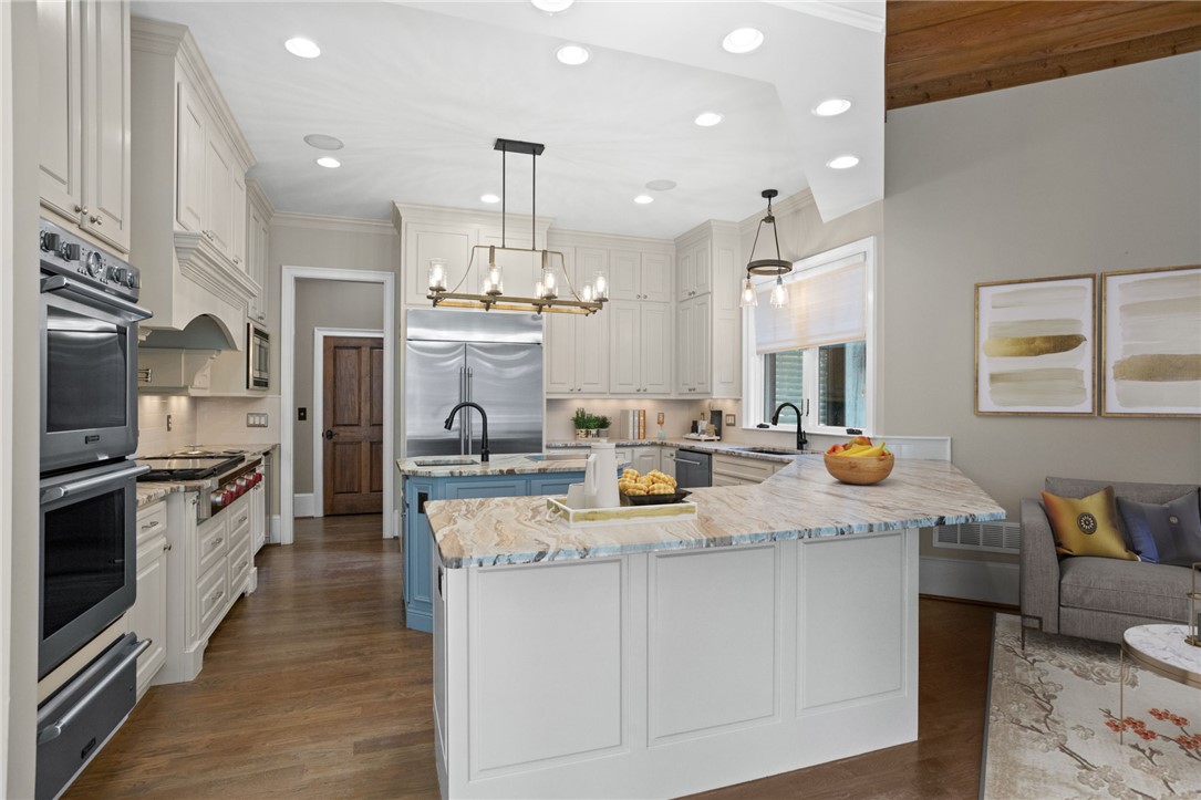 314 Palmer Way Sunset, SC 29685 - Photo 9 of 48 Rich hardwood flooring complements a spacious custom kitchen featuring dual islands and stone countertops.