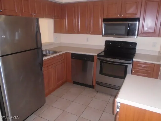 a kitchen with a refrigerator sink and cabinets