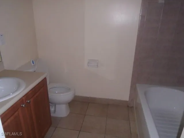 a bathroom with a granite countertop toilet and sink