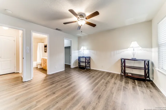 a view of livingroom with furniture chandelier fan and windows