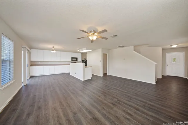 a view of empty room with wooden floor and window