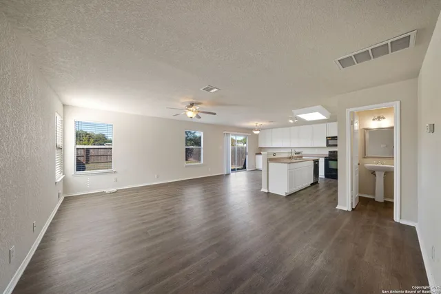 a view of a kitchen with a sink stove cabinets and empty room