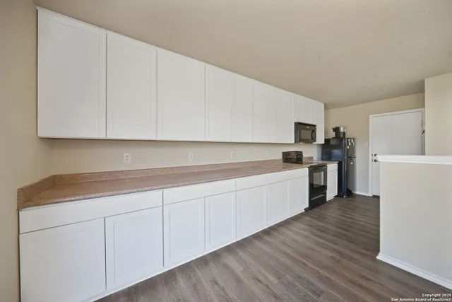 a kitchen with granite countertop white cabinets and white appliances
