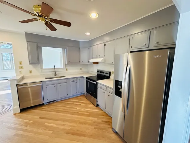 a kitchen with a sink a refrigerator and cabinets