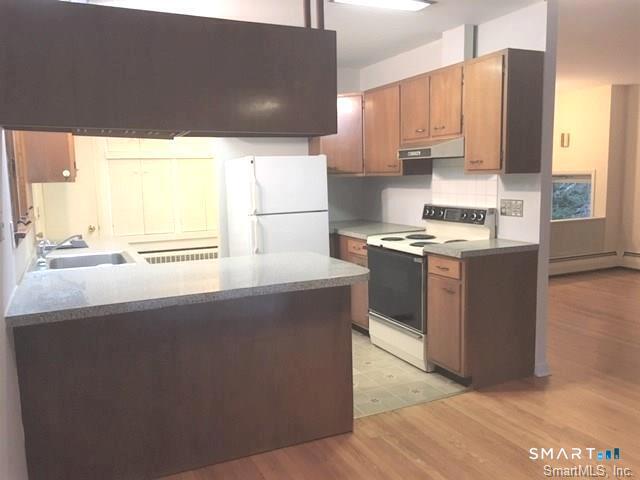 146 Scribner Hill Road Wilton, CT 06897 - Photo 2 of 13 a kitchen with stainless steel appliances a stove a sink a refrigerator with grey cabinets and wooden floor