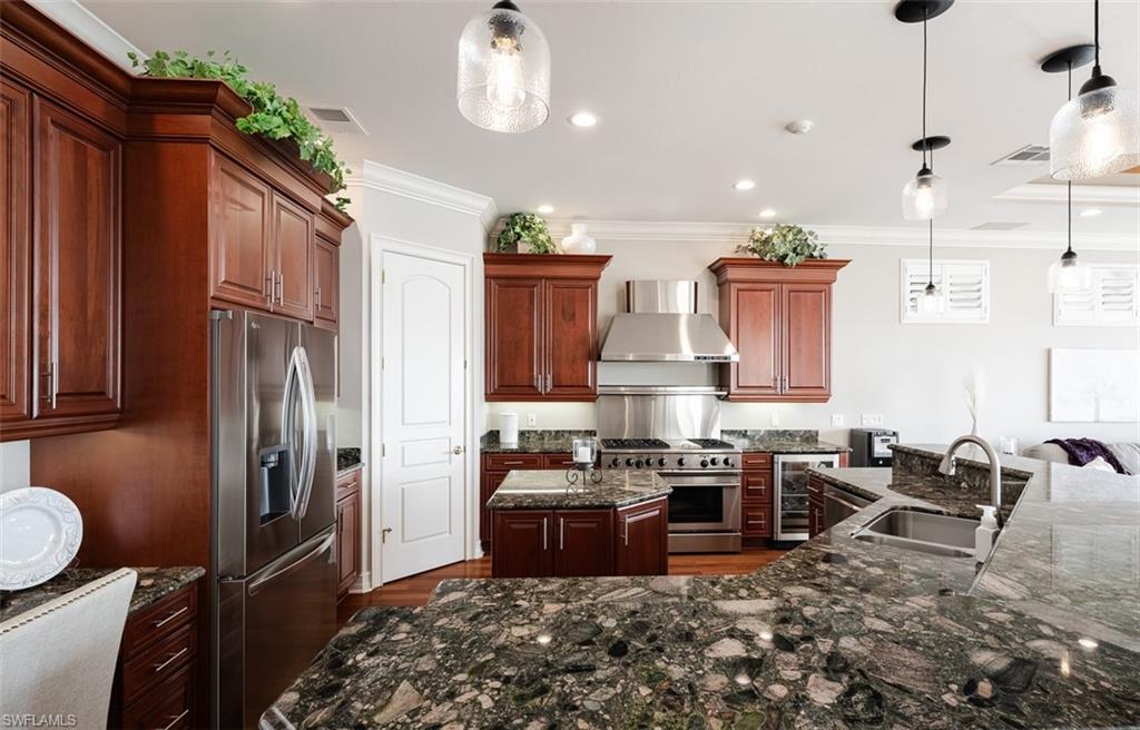 1942 Kingfish Road Naples, FL 34102 - Photo 17 of 43 a kitchen with stainless steel appliances granite countertop a sink stove and refrigerator