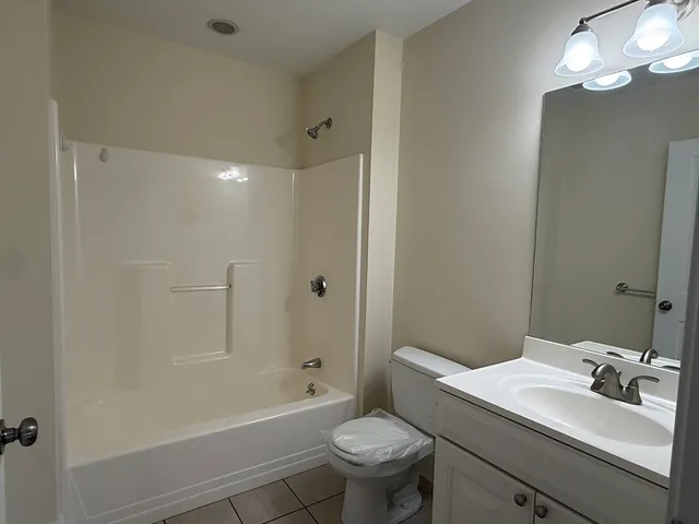 a bathroom with a sink toilet vanity and shower