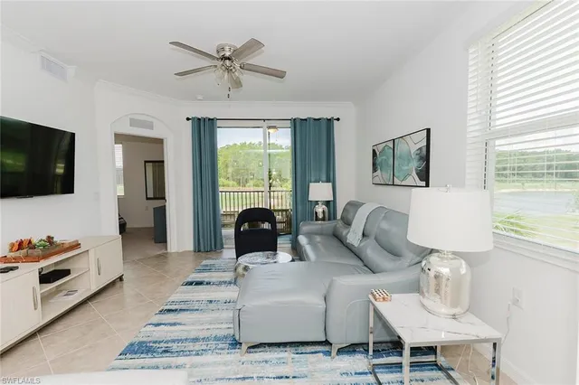 a living room with furniture a flat screen tv and a window
