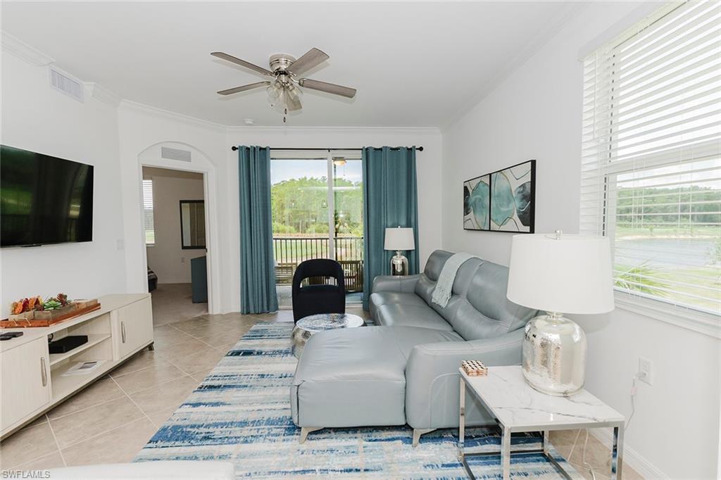 6034 National Boulevard, Unit 528 Ave Maria, FL 34142 - Photo 13 of 43 a living room with furniture a flat screen tv and a window