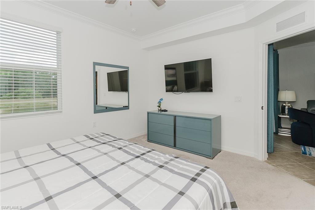 6034 National Boulevard, Unit 528 Ave Maria, FL 34142 - Photo 16 of 43 a bedroom with a bed and a television