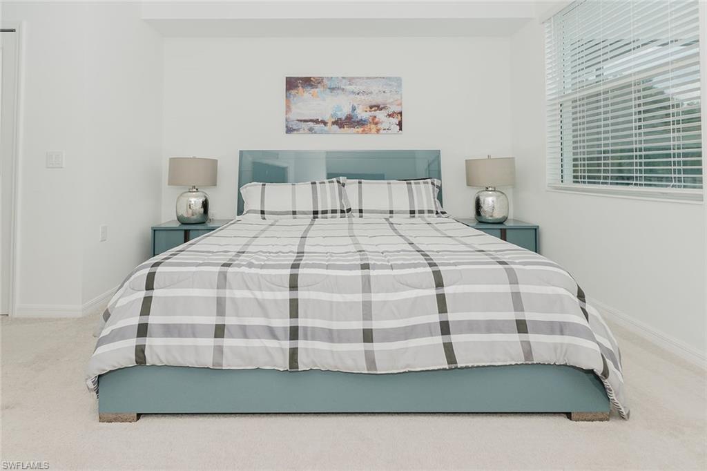 6034 National Boulevard, Unit 528 Ave Maria, FL 34142 - Photo 17 of 43 a bed sitting in a bedroom next to a window