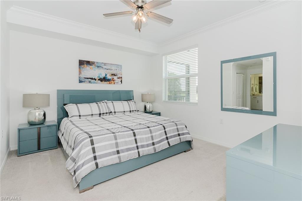 6034 National Boulevard, Unit 528 Ave Maria, FL 34142 - Photo 18 of 43 a bedroom with a bed and a chandelier