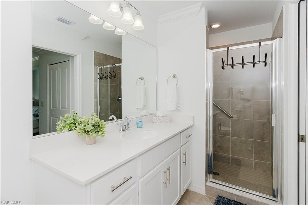 6034 National Boulevard, Unit 528 Ave Maria, FL 34142 - Photo 19 of 43 a bathroom with a sink a mirror and a shower