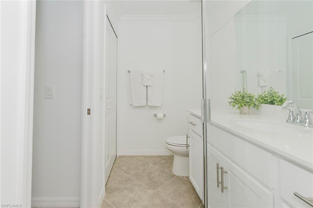 6034 National Boulevard, Unit 528 Ave Maria, FL 34142 - Photo 20 of 43 a bathroom with a granite countertop toilet and a sink