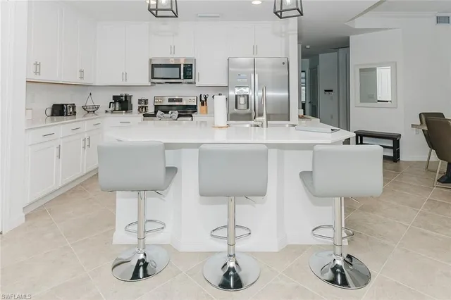 a kitchen with a sink and chairs