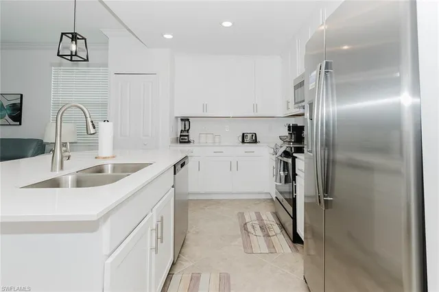 a kitchen with a sink refrigerator and cabinets