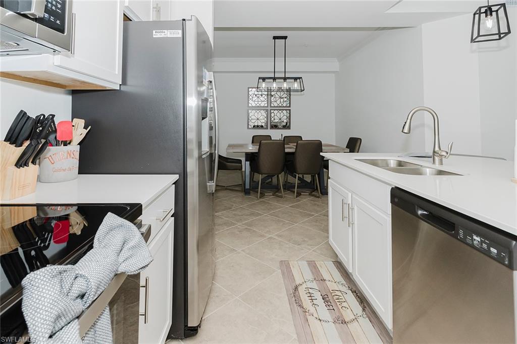 6034 National Boulevard, Unit 528 Ave Maria, FL 34142 - Photo 10 of 43 a kitchen with a sink refrigerator and cabinets